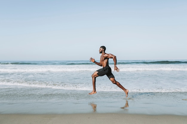 Fit man loopt op het strand