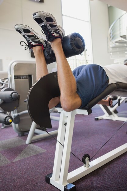 Fit man met behulp van gewichten machine voor benen