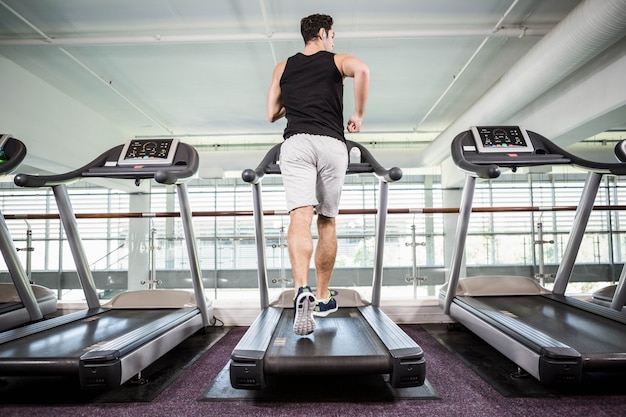 Fit man running on treadmill at the gym