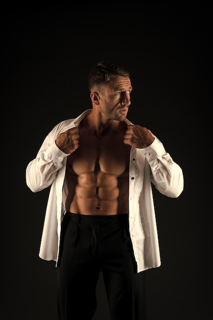 Fit man show six pack abs torso in open shirt formele stijl zwarte achtergrond business