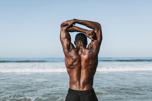 Photo fit man stretching at the beach