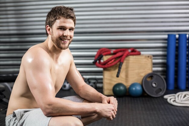 Fit man taking a break from working out at crossfit gym