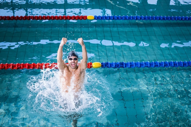 Fit man triomfeert in het zwembad