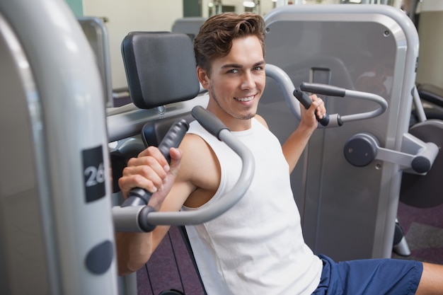 Fit man using weights machine for arms