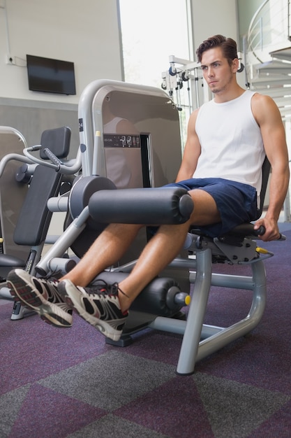 Fit man using weights machine for legs