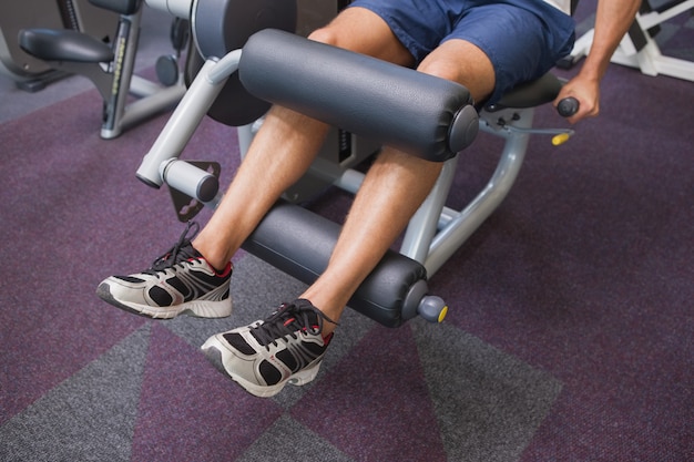 Premium Photo | Fit man using weights machine for legs