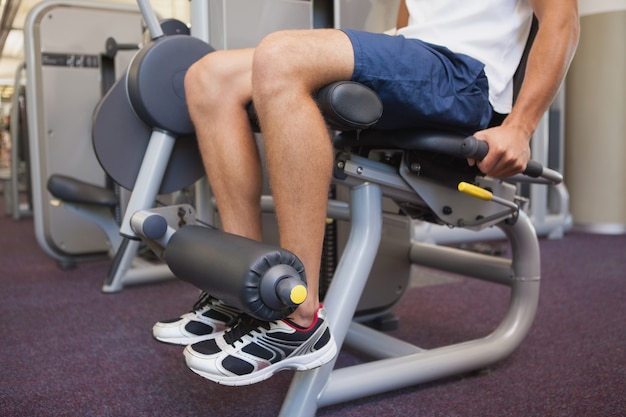 Fit man using weights machine for legs