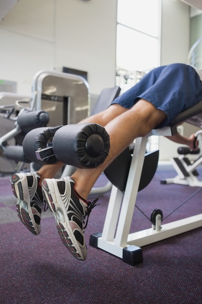 Fit man using weights machine for legs