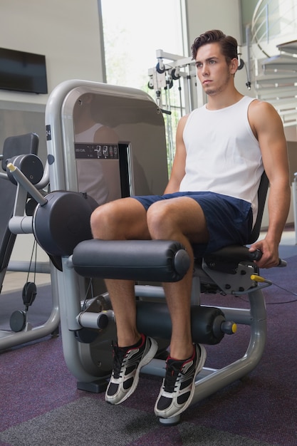 Fit man using weights machine for legs