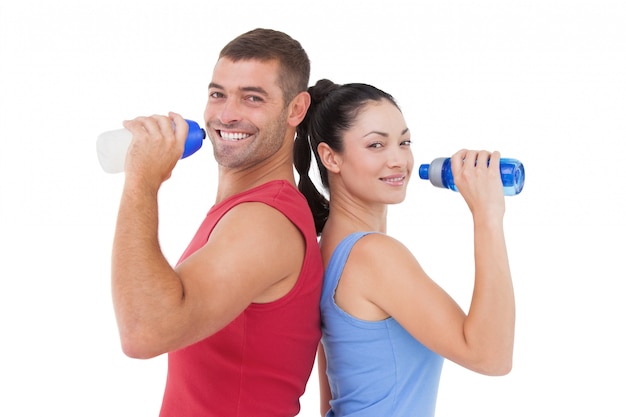 Fit man and woman smiling at camera together