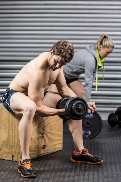 Fit man and woman working out at gym