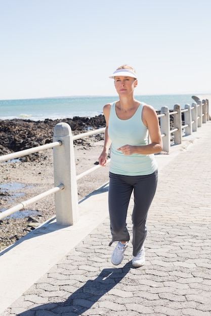 Fit mature woman jogging on the pier