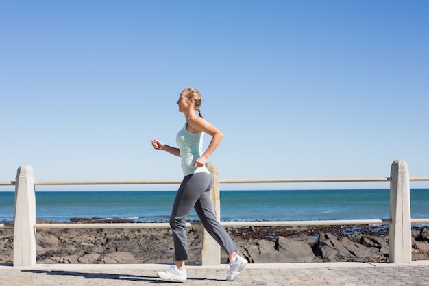 Fit mature woman jogging on the pier