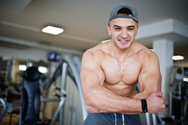 Fit and muscular arabian man doing workouts in gym