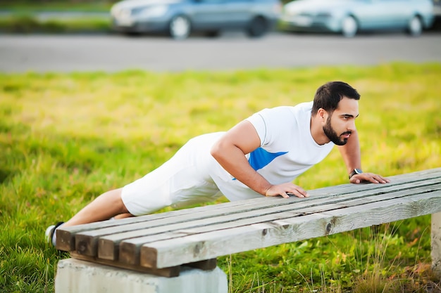 Fit muscular man running and doing exercise outside