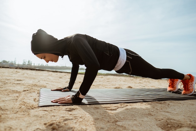 Photo fit muslim woman doing push up outdoor