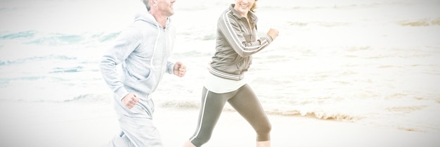 Fit paar joggen samen op het strand