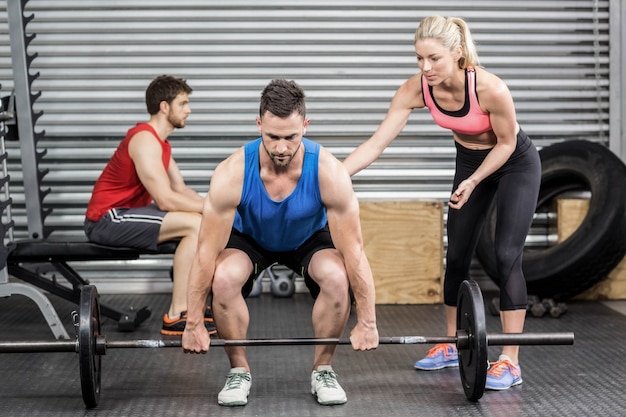 Fit people doing exercises at crossfit gym