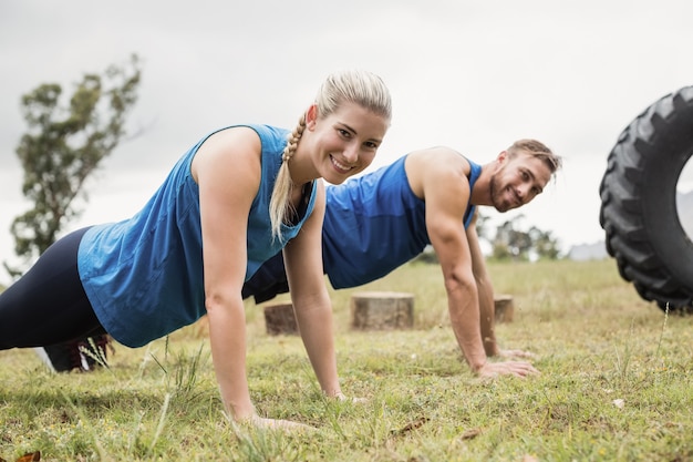 Photo fit people performing pushup exercise in boot camp