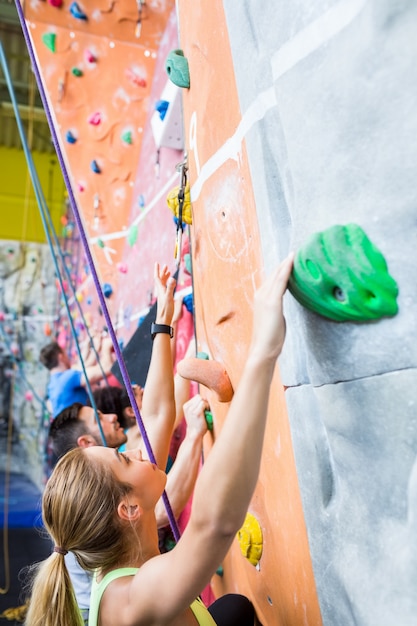 Fit people rock climbing indoors