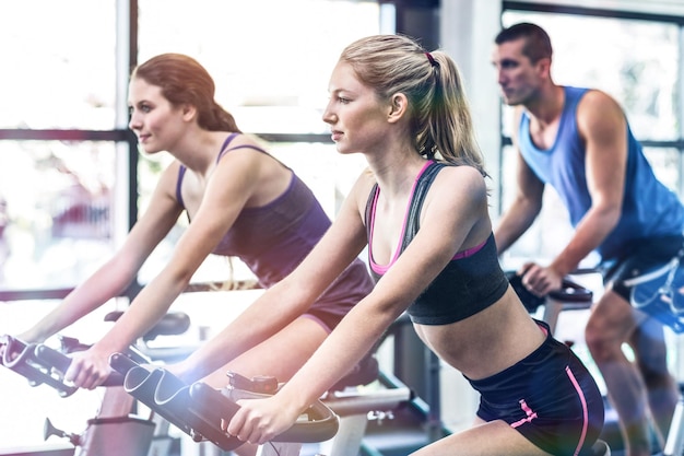 Fit people working out at spinning class in gym