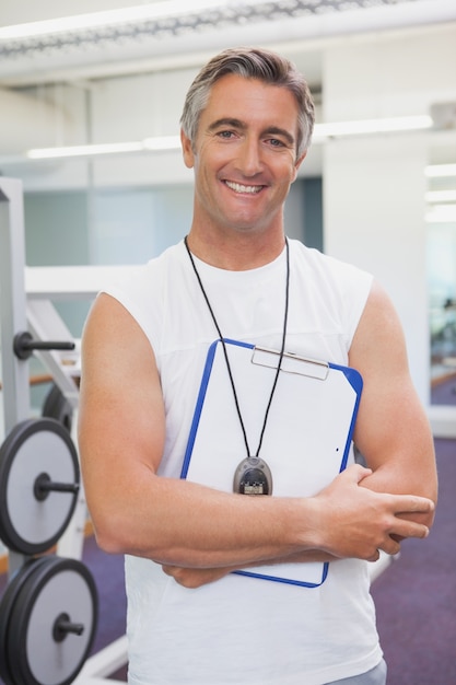 Fit personal trainer smiling at camera in fitness studio