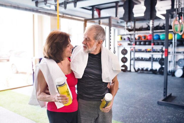 Fit senior couple in gym taking a break