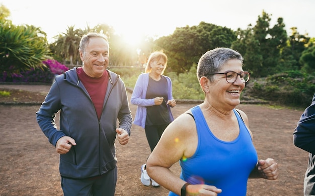 Photo fit senior people running at city park group of elderly friends doing sport workout together outdoor main focus on left man face