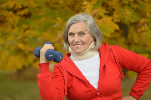 Fit Senior woman exercising with dumbbells