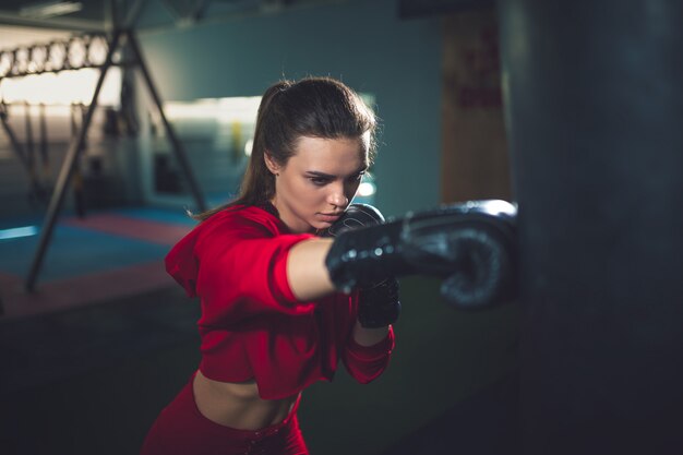 Fit slim young beautiful brunette woman boxing in sportswear