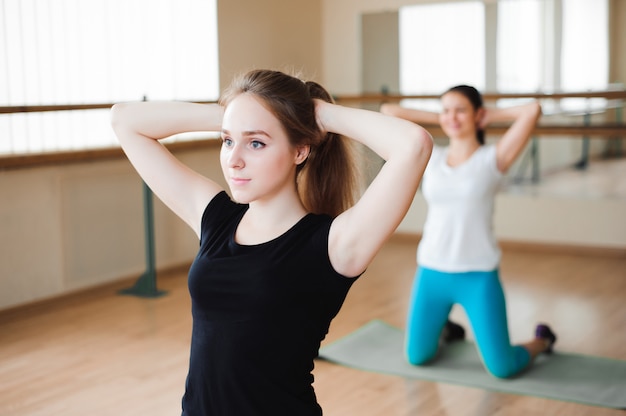 Gruppo sorridente adatto che fa esercizio in palestra