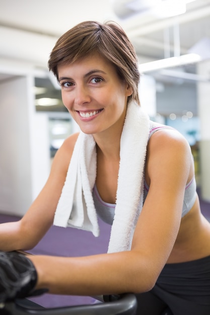 Photo fit smiling woman working out on the exercise bike