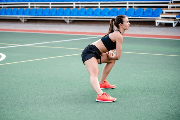 Fit sportieve vrouw doet fitness training en trainen in het stadion in de ochtend