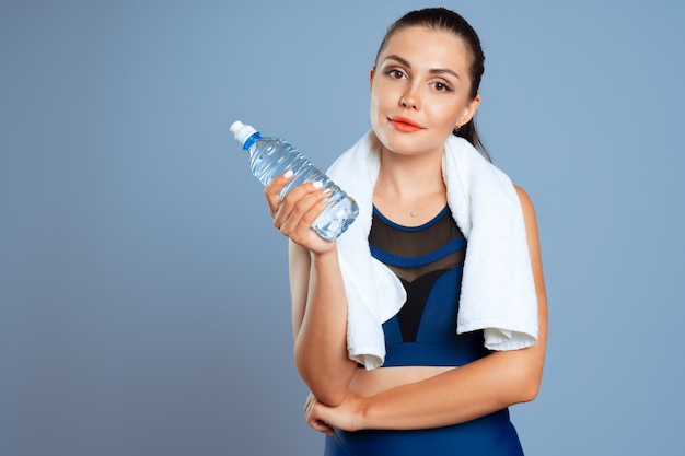 Fit sportieve vrouw met mineraal water fles in haar hand