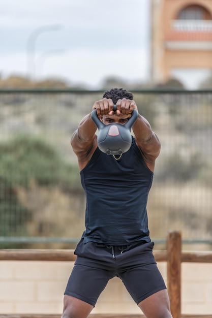 Fit sportsman performing kettlebell swing exercise during workout