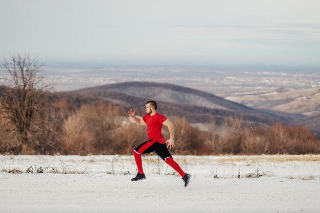 冬の自然の中で雪の上を全力疾走するスポーツマンに合いましょう。冬のフィットネス、健康的な生活