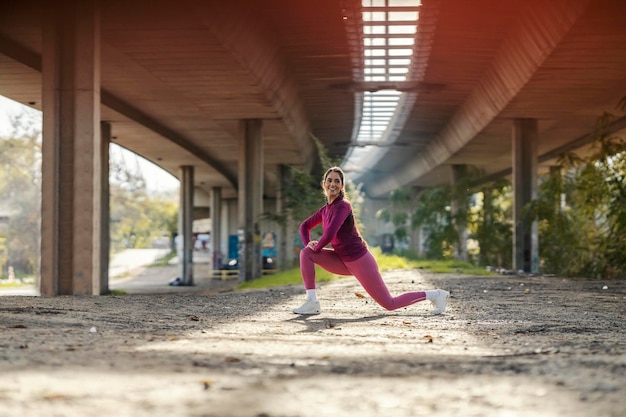 A fit sportswoman in shape is stretching her outside