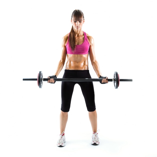 Foto giovane donna adatta e sportiva che fa i pesi sopra fondo bianco.