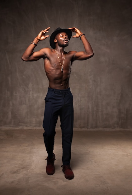 Fit strong physique young man singing dancing under the rain