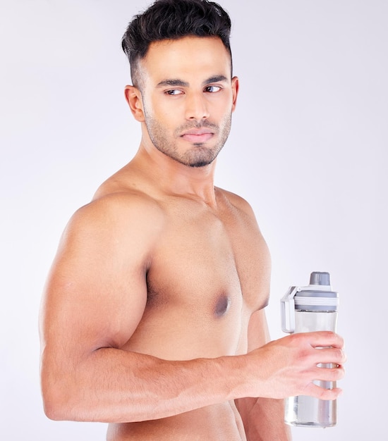 Подходит сильный и тренировочный перерыв и бутылка с водой с мужчиной, готовым пить воду на сером студийном фоне