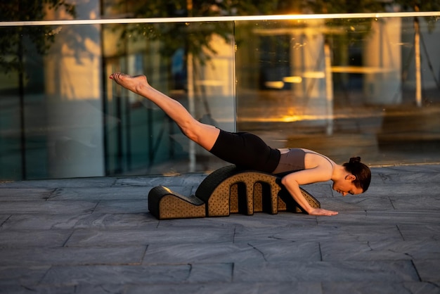 Fit vrouw doet pilates op boogvat buitenshuis