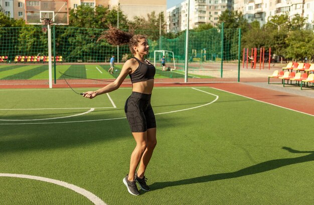 Fit vrouw in sportkleding touwtjespringen buitenshuis