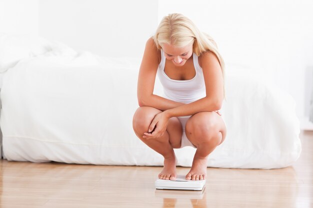 Fit vrouw op een wegende machine