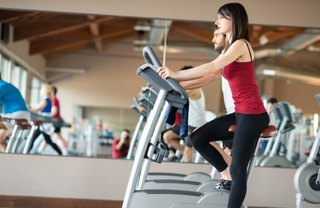 Fit vrouw trainen in een sportschool op een hometrainer