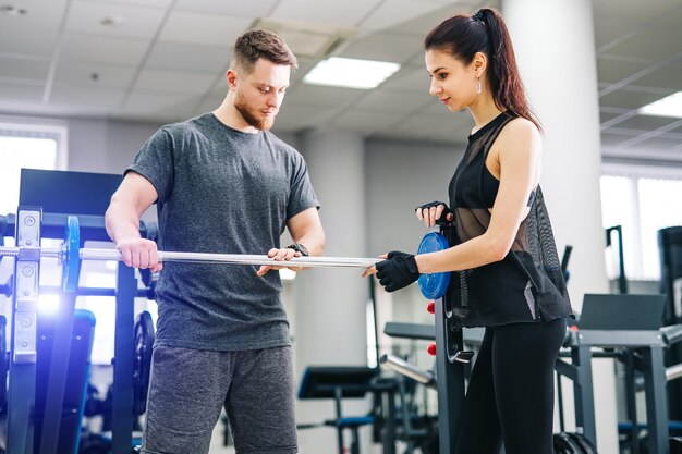 Fit vrouw trainen met trainer in de sportschool.