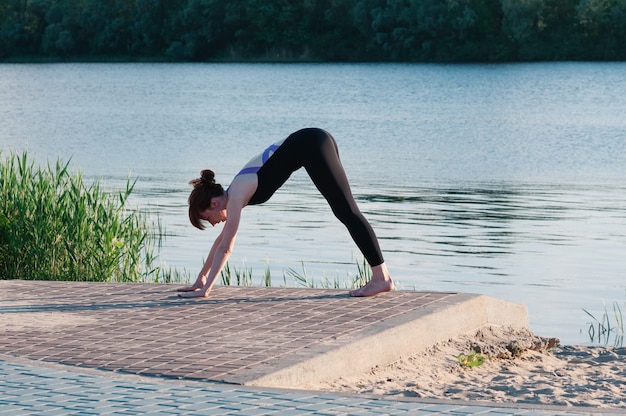 Fit vrouwelijke praktijk yoga-oefening in de open lucht