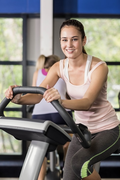 Fit woman doing exercise bike at gym