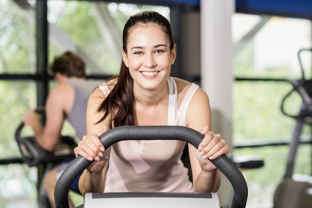 Fit woman doing exercise bike at gym