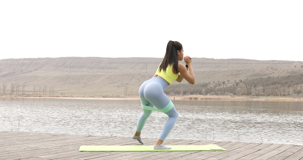 Подходящая женщина делает упражнения с полосой сопротивления.