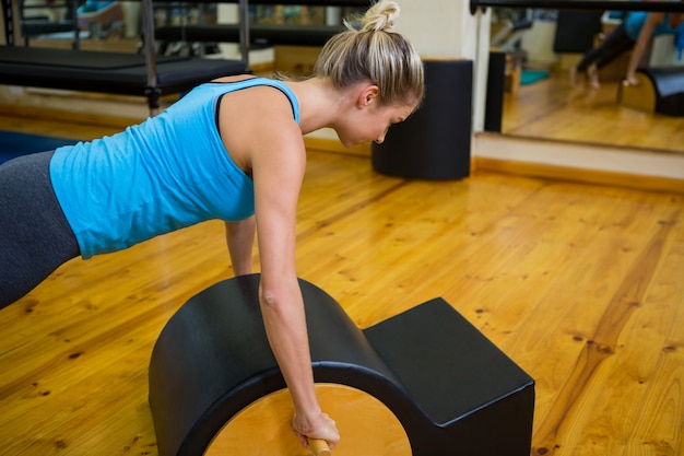 Fit woman doing pilates on arc barrel